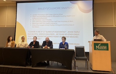 people sitting at panel at conference