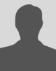 A flat, dark grey icon of a person on a solid light grey background.